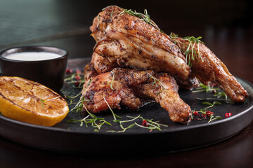 Two grilled chicken legs with sauce and lemon