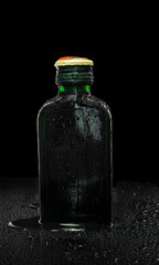 small green glass bottle on black background