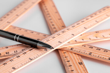 Close up of metric and imperial rulers on white background