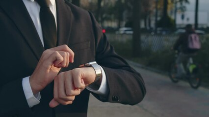  Businessman is typing message on the smartwatch.  .Businessman  looks on the smartwatch and typing text. Modern gadgets and people concept. Modern communication. Close up, slow motion footage. - Powered by Adobe