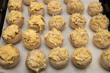 champignons stuffed with cheese and garlic on a baking sheet