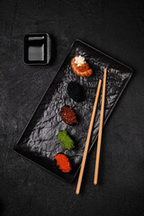 Set of Gunkan Maki Sushi with different types of fish and caviar on black background