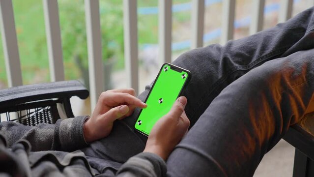 Person scrolling on iphone green screen