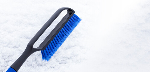 Blue brush for cleaning the car from snow with space for text. Concept banner of cleaning tools for...