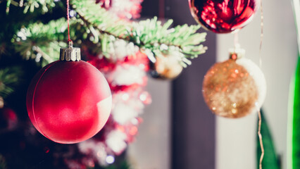Christmas ball hung on the Christmas tree with tinsel garland