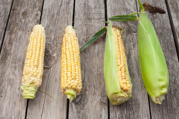 a few cobs of corn are on the table.