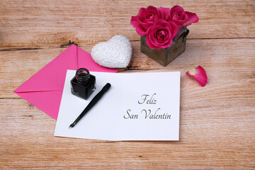 Tarjeta de felicitación del día de San Valentín con pluma estilográfica, tinta, flores y corazón.
