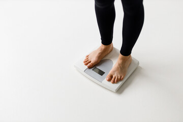 Women's feet on the scales, weight loss and diet concept, copy space for text.