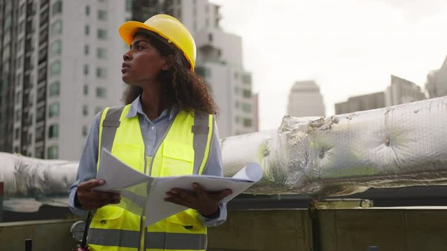 Civil engineer woman dark skin wearing uniform and safety helmet under inspection and checking plan on factory plant station by tablet.Civil Engineer,Industry,construction,Industry maintenance concept