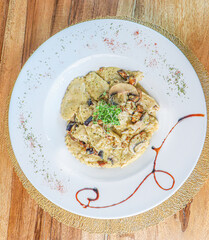 Risotto with mushrooms on an old wooden background. Rustic style.