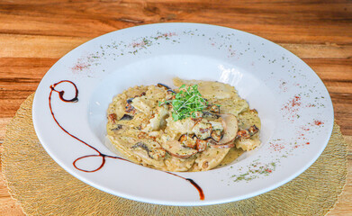 Risotto with mushrooms on an old wooden background. Rustic style.