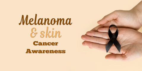 The woman 's hands are holding black Ribbon for symbol Melanoma and skin cancer. Narcolepsy, Primary Biliary Cirrhosis, Sleep Apnea Disorders
