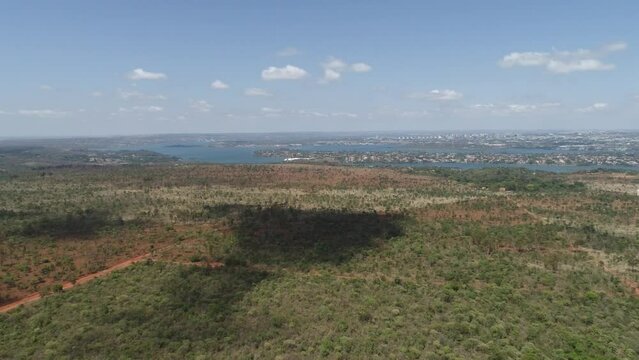 Drone flying over a field towards the city.
