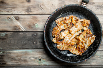 Fried bacon in a pan.