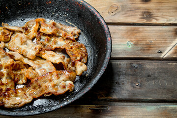 Fried bacon in a pan.