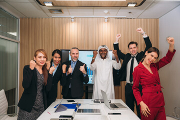 Businesspeople are laughing and giving each other stack of hands as they to show the succes of project. The concept of teamwork.