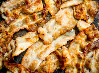 Fried bacon in a frying pan.