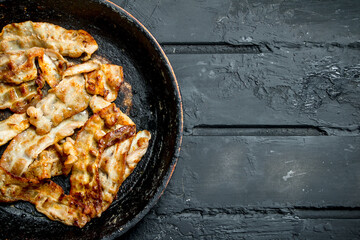 Fried bacon in a frying pan.