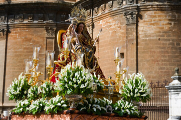 A paso of the Virgin Mary carried in a religious procession past the Cathedral in Seville, Southern...