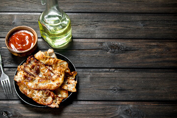 Fried bacon with tomato sauce.