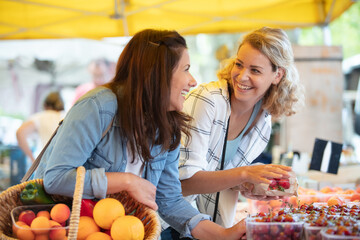 women choose fruits and vegetables at a food market