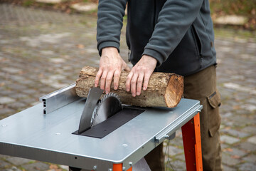 Großes Stück Holz mit Kreissäge klein sägen