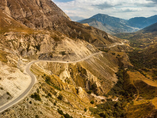 Winding road in the Dagestan Mountains with big mountain formation in the background. Russia