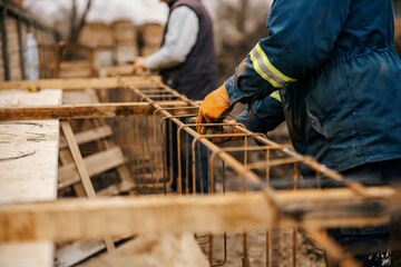 Close up of builders making house foundation on construction site.