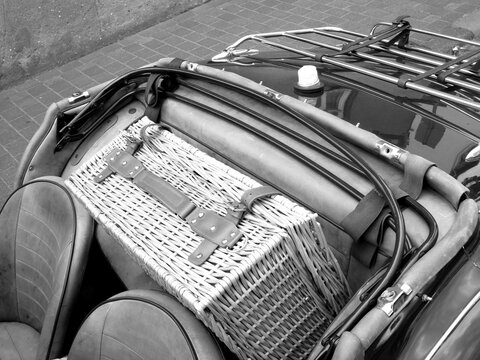 Picknickkoffer aus Korbgeflecht auf dem Notsitz eines englischen Roadster der F&uuml;nfzigerjahre beim Oldtimertreffen Golden Oldies in Wettenberg Krofdorf-Gleiberg bei Gie&szlig;en in Hessen in Schwarzwei&szlig;