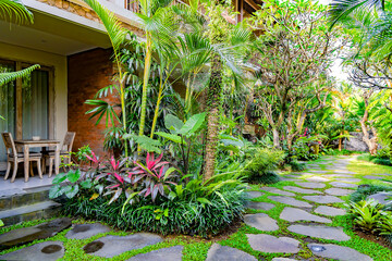 Outdoor veranda with ecological wooden furniture surrounded by a beautiful tropical garden in Ubud, Bali, Indonesia.	
