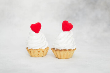 two cakes with red hearts on a gray background.