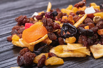 wooden background in retro style. a mixture of dried fruits lies on it. close-up. there is a...