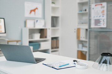 Laptop, medical document and other supplies on veterinarian workplace
