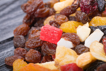 wooden background in retro style. a mixture of dried fruits lies on it. close-up. there is a tinting. soft focus.