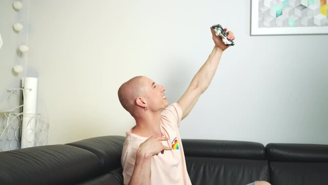 Young man with LGBT symbols holding phone and filming himself on the front camera. High quality 4k footage