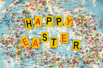Multicolored sprinkles on turquoise background, festive decoration for banner, poster, flyer, card, card, cover, brochure with the inscription "Easter" in multicolored letters