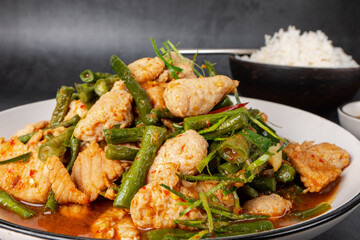  Tasty Stir-fried pork and red hot curry paste with asparagus bean or long bean and  Ingredients are oyster sauce, fish sauce, sugar, kaffir lime leaves in the dish Eat with cooked rice. Thai cuisine