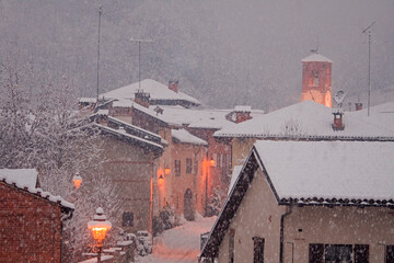 Beautiful Christmas scene of an intense snowfall in a country town with the houses and the bell...