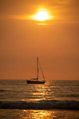 Sailboat at sunset on a hot summer evening.