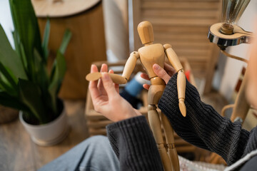 Fototapeta premium Cropped view of artist holding wooden doll in workshop