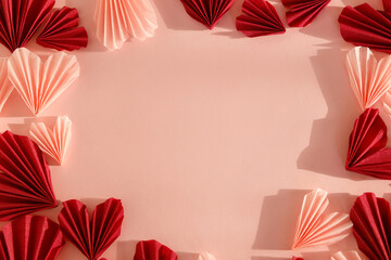 Fototapeta na wymiar Happy Valentine's day! Stylish pink and red hearts flat lay on pink paper background. Modern cute valentine hearts cutouts in frame, with space for text. Creative love background