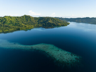 A coral reef fringes a lush, tropical islands found in a remote part of the Solomon Islands. This beautiful Melanesian island nation harbors extraordinary marine and terrestrial biodiversity.