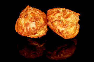 Two sweet chouquette, close-up, isolated on black.