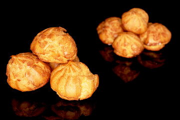 Several fragrant delicious Chouquettes, close-up, on a black background.