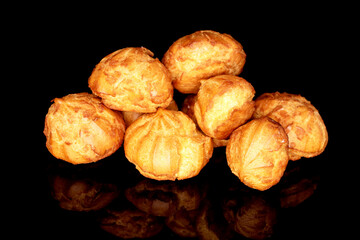Several fragrant delicious Chouquettes, close-up, on a black background.