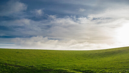 Dramatic clouds over a lush green field