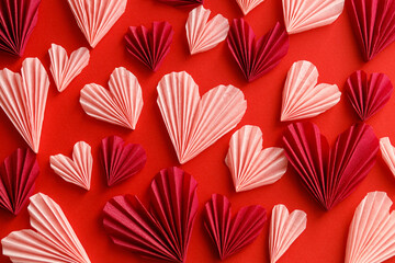 Valentines day flat lay. Stylish pink hearts composition on red paper background. Happy Valentine's day! Modern cute valentine heart cutouts. Creative love banner