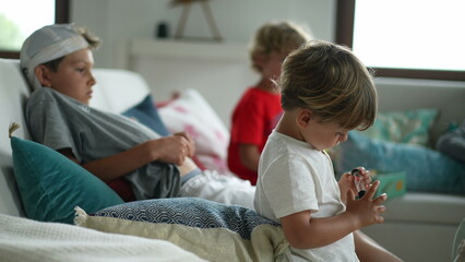Obraz premium Children at home sitting at sofa. Kids staying home