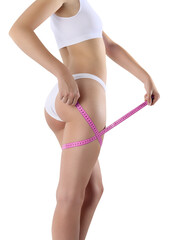 Female body, young slim woman in underwear measures the circumference of thigh with a tape measure, isolated on a transparent background, concept of body care, healthy diet and cellulite treatment.