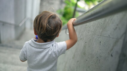 Child walking down stais holding handrail2